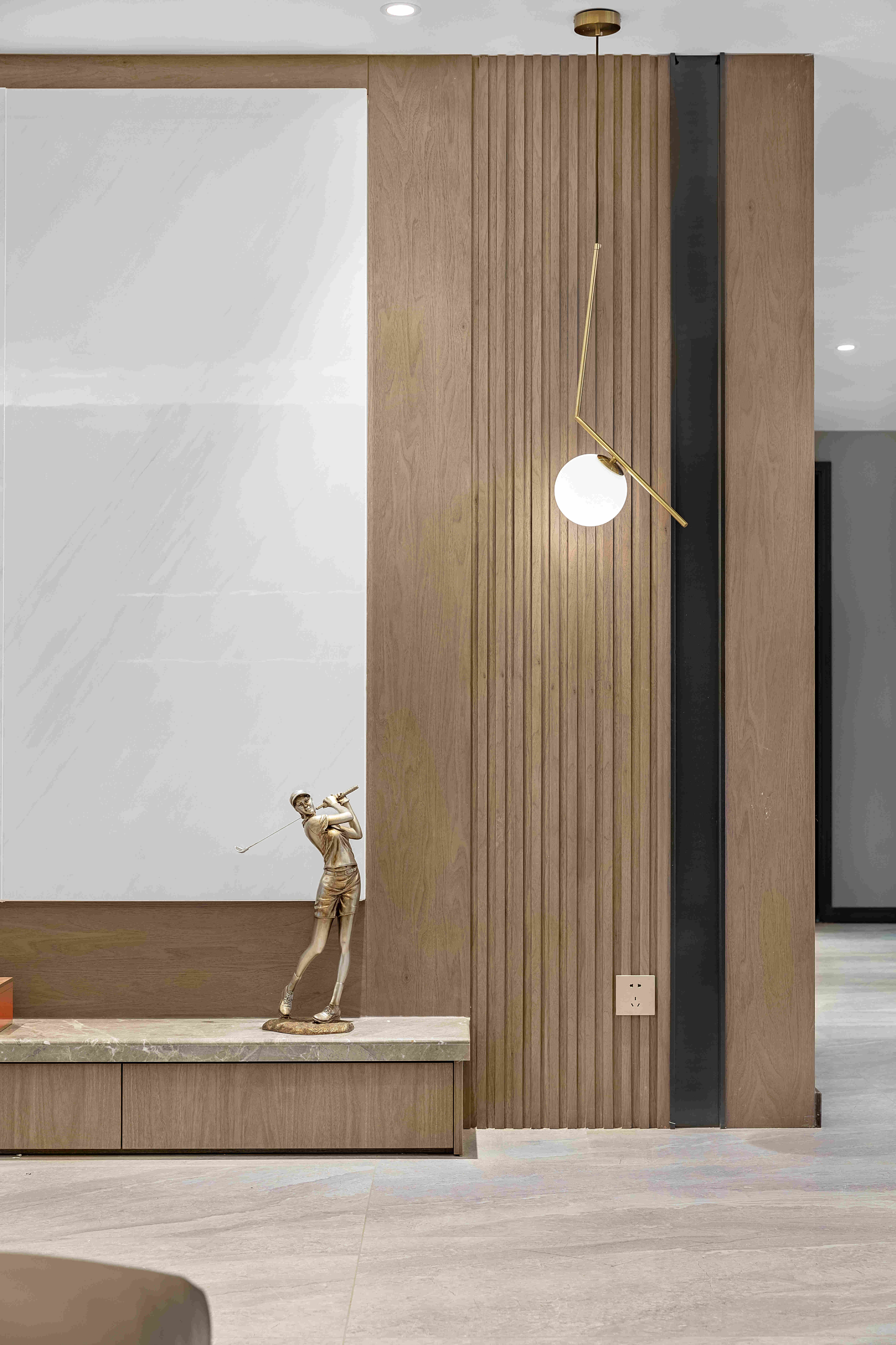 石材、墙板、线条灯相互呼应，全透灰玻酒柜，就不会遮挡走廊视线，造型硬朗还会给予空间更多丰富的层次感和立体感。